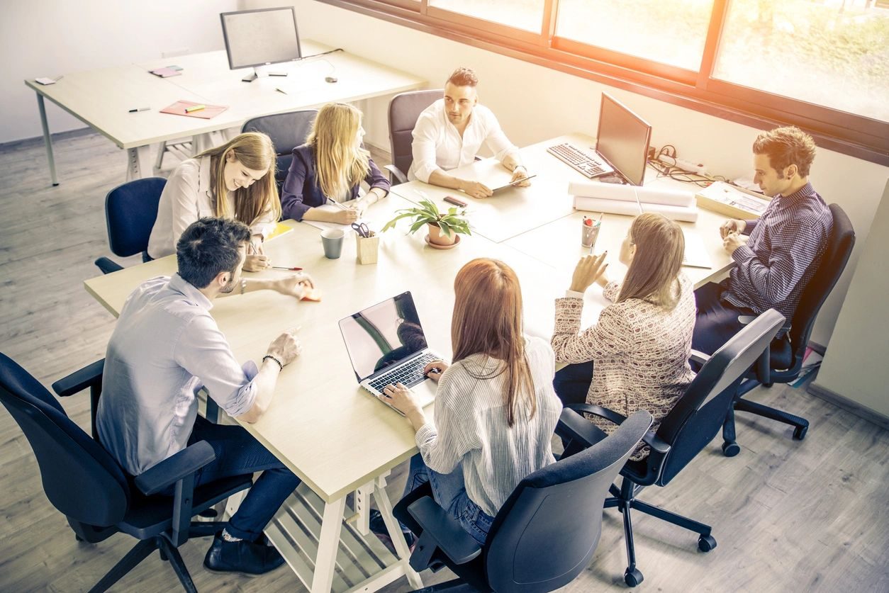 Team collaborating in a bright office meeting.